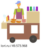Man selling hot dogs in kiosk at street vector, isolated character with bun and sausage. Cooking male with ketchup and mustard, service eatery or diner. Hot Dog Seller Stall with Street Food Service. Стоковая иллюстрация, агентство Ingram Publishing / Фотобанк Лори