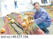 a man organising fishing nets. Стоковое фото, агентство Ingram Publishing / Фотобанк Лори