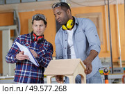 carpentry apprentice with belt sander grinding wood. Стоковое фото, агентство Ingram Publishing / Фотобанк Лори