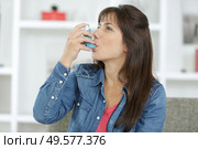 woman using inhalator to cope with asthma. Стоковое фото, агентство Ingram Publishing / Фотобанк Лори