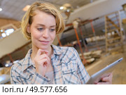 Lady in industrial building, looking at tablet. Стоковое фото, агентство Ingram Publishing / Фотобанк Лори