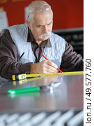 senior man installing and measuring a shower box at home. Стоковое фото, агентство Ingram Publishing / Фотобанк Лори