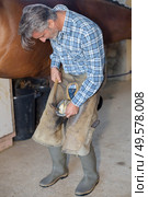 a man attaching a hoof. Стоковое фото, агентство Ingram Publishing / Фотобанк Лори