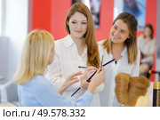 students taking notes as hairdresser demonstrates style on mannequin. Стоковое фото, агентство Ingram Publishing / Фотобанк Лори