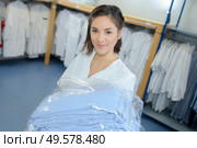 Portrait of woman with laundered uniforms. Стоковое фото, агентство Ingram Publishing / Фотобанк Лори