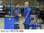 student with instructor repairing a car during apprenticeship. Стоковое фото, агентство Ingram Publishing / Фотобанк Лори
