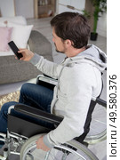 happy handicapped man watching television in living room. Стоковое фото, агентство Ingram Publishing / Фотобанк Лори