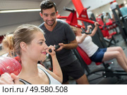 helping a woman lift the dumbbells. Стоковое фото, агентство Ingram Publishing / Фотобанк Лори