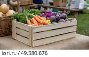 Freshly harvested vegetables in a wooden crate on green grass in sprin. Свежесобранные овощи в деревянном ящике на зеленой траве весной. Стоковое AI-изображение, AI-художник Katsiaryna Repich / Фотобанк Лори