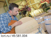 a male worker inspecting the drum quality. Стоковое фото, агентство Ingram Publishing / Фотобанк Лори