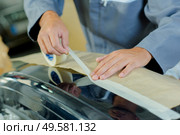 a mechanic applying masking tape. Стоковое фото, агентство Ingram Publishing / Фотобанк Лори