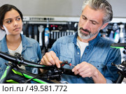 bicycle technician mending bike handlebar problem. Стоковое фото, агентство Ingram Publishing / Фотобанк Лори