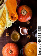 baked pumpkin cream coup with, walnuts ,  coconut milk and natural honey. served at wooden brown table with ripe orange  pumkins. flat lay. healthy life concept. Стоковое фото, агентство Ingram Publishing / Фотобанк Лори