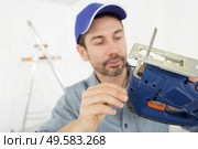 carpenter is holding a jig saw machine in carpentry. Стоковое фото, агентство Ingram Publishing / Фотобанк Лори