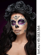 Portrait of a woman with sugar skull makeup over red background. Halloween costume and make-up. Portrait of Calavera Catrina. Стоковое фото, агентство Ingram Publishing / Фотобанк Лори