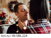 a guy and a girl celebrate the new year togetherin a warm atmosphere and give each other gifts. Стоковое фото, агентство Ingram Publishing / Фотобанк Лори