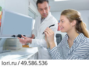 Woman with optician holding glasses. Стоковое фото, агентство Ingram Publishing / Фотобанк Лори