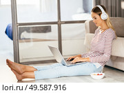 Caucasian blond woman with headphones and laptop on the sofa at home.. Caucasian blond woman with headphones and laptop on the sofa. Стоковое фото, агентство Ingram Publishing / Фотобанк Лори