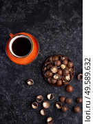 natural  macadamia nuts and black coffee served at black table.food  and wellness concept . Стоковое фото, агентство Ingram Publishing / Фотобанк Лори