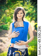 mother with a sleeping newborn baby in a baby carrier. mother with newborn baby in a sling. Стоковое фото, агентство Ingram Publishing / Фотобанк Лори