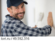 smiling painter with roller painting a wall. Стоковое фото, агентство Ingram Publishing / Фотобанк Лори