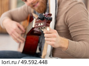 young adult tuning classic guitar. Стоковое фото, агентство Ingram Publishing / Фотобанк Лори