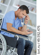 young man using a tablet in a wheelchair. Стоковое фото, агентство Ingram Publishing / Фотобанк Лори