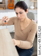 asian woman changing light bulb. Стоковое фото, агентство Ingram Publishing / Фотобанк Лори