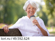 senior woman drinking take away coffee in the park. Стоковое фото, агентство Ingram Publishing / Фотобанк Лори