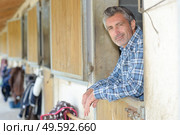 stable worker poses in horse stable. Стоковое фото, агентство Ingram Publishing / Фотобанк Лори