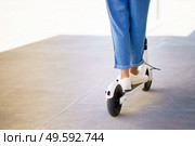 Detail of woman circulating in the city with an electric scooter. Woman circulating in the city with an electric scooter. Стоковое фото, агентство Ingram Publishing / Фотобанк Лори