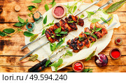 Kebab on skewers with nettle marinade.Meat on skewers,barbecue. Shish kebab marinated in nettles. Стоковое фото, агентство Ingram Publishing / Фотобанк Лори