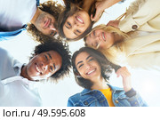Multi-ethnic group of friends with their heads together in a circle outdoors. Multi-ethnic group of friends with their heads together in a circle. Стоковое фото, агентство Ingram Publishing / Фотобанк Лори