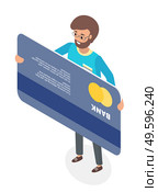 A happy man standing holding his credit card isolated on white. Micro male character in glasses and big plastic bank card turned opposite side. Concept of cashless financial transactions, big shopping. A happy man standing holding his credit card. Micro male character and big plastic bank card. Стоковая иллюстрация, агентство Ingram Publishing / Фотобанк Лори