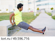 Black man doing triceps dip exercise on city street bench. Fitness, sport, exercising, training and people concept. Black man doing triceps dip exercise on city street bench. Стоковое фото, агентство Ingram Publishing / Фотобанк Лори