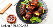 Roasted sliced barbecue ribs on the plate.Smoked beef ribs with bone and gravy. Roasted beef brisket on the ribs. Стоковое фото, агентство Ingram Publishing / Фотобанк Лори