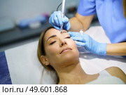 Permanent make-up for eyebrows of beautiful woman in a beauty salon. Close-up of beautician doing tattooing eyebrow. Micropigmentation treatment.. Permanent make-up for eyebrows of beautiful woman in a beauty salon. Micropigmentation treatment. Стоковое фото, агентство Ingram Publishing / Фотобанк Лори