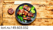 Spicy barbecue beef ribs with herb on rustic wooden table.BBQ beef rib. Roasted beef brisket on the ribs. Стоковое фото, агентство Ingram Publishing / Фотобанк Лори