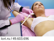 Doctor painting on the armpit of her middle-aged patient, the area to be treated for hyperhidrosis.. Doctor painting on the armpit of her patient, the area to be treated for hyperhidrosis. Стоковое фото, агентство Ingram Publishing / Фотобанк Лори