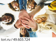 Hands of a multi-ethnic group of friends joined together as a sign of support and teamwork. Young people having fun together.. Hands of a multi-ethnic group of friends joined together as a sign of support and teamwork. Стоковое фото, агентство Ingram Publishing / Фотобанк Лори