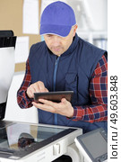 repairer man fixing printer using digital tablet. Стоковое фото, агентство Ingram Publishing / Фотобанк Лори