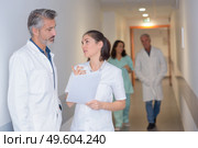 Nurse and doctor talking in hospital corridor. Стоковое фото, агентство Ingram Publishing / Фотобанк Лори