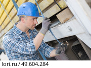 Man strapping load on to vehicle. Стоковое фото, агентство Ingram Publishing / Фотобанк Лори