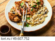 Turkey meat in cheese breading with mushroom sauce. Turkey schnitzel with fried mushrooms. Стоковое фото, агентство Ingram Publishing / Фотобанк Лори