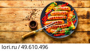 Delicious grilled sausages with grilled vegetables. Sausages fried with pepper.Copy space. Delicious grilled sausages,space for tex. Стоковое фото, агентство Ingram Publishing / Фотобанк Лори