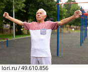 Senior man doing warming up exercises. Стоковое фото, фотограф Татьяна Яцевич / Фотобанк Лори