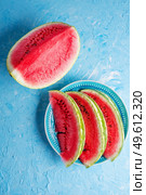cutted part of  ripe  watermelon and slices at plate around blue background. Стоковое фото, агентство Ingram Publishing / Фотобанк Лори