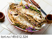 Fish baked in herbs and meadow hay. Roasted sea bass. Seabass fish baked with spicy herbs. Стоковое фото, агентство Ingram Publishing / Фотобанк Лори