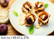 Figs stuffed with suluguni cheese baked with bacon and Greek yogurt sauce.. Figs roasted in bacon with cheese. Стоковое фото, агентство Ingram Publishing / Фотобанк Лори