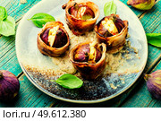 Figs stuffed with suluguni cheese baked with bacon and Greek yogurt sauce.. Figs roasted in bacon with cheese. Стоковое фото, агентство Ingram Publishing / Фотобанк Лори